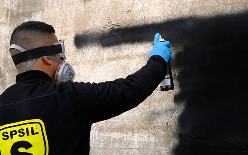 Persona pintando una pared con spray de alta cobertura